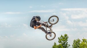 Niedrigwinkelansich eines Mannes der einen Stunt auf einem BMX Bike gegen den Himmel ausführt | © EyeEm | Freepik