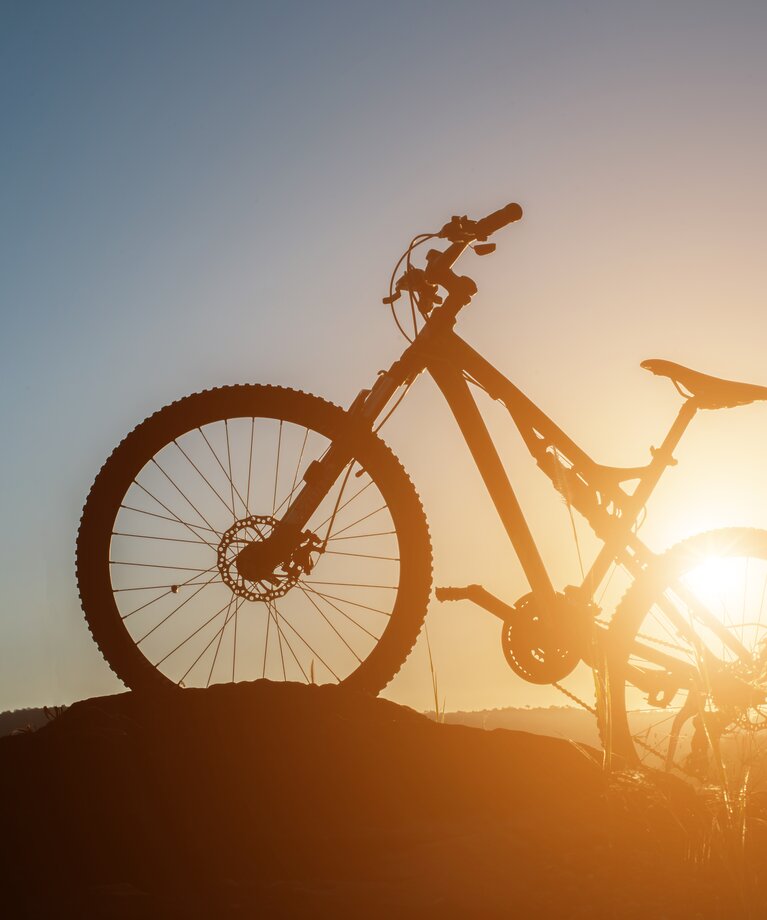 Ein Mountainbike bei Sonnenuntergang | © Freepik | Jcomp